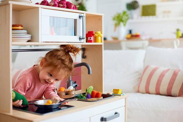 little girl playing in toy kitchen